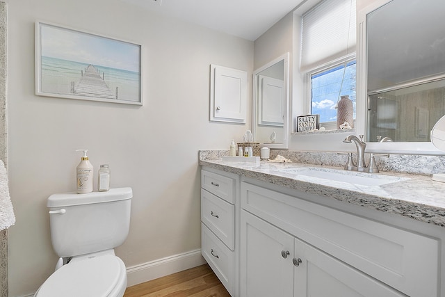 full bathroom with toilet, baseboards, wood finished floors, a shower stall, and vanity