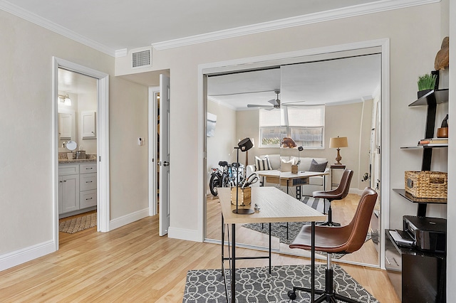 home office with light hardwood / wood-style floors, ornamental molding, and ceiling fan