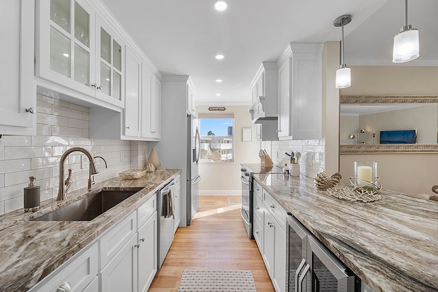 kitchen featuring sink, light wood-type flooring, white cabinetry, stainless steel appliances, and light stone counters