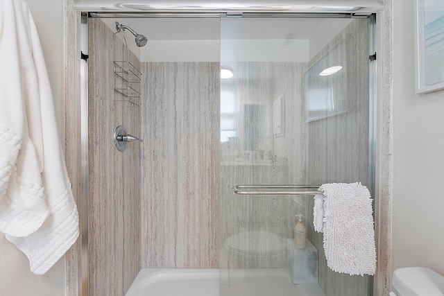 bathroom with enclosed tub / shower combo and toilet