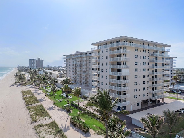 view of building exterior featuring a water view and a beach view