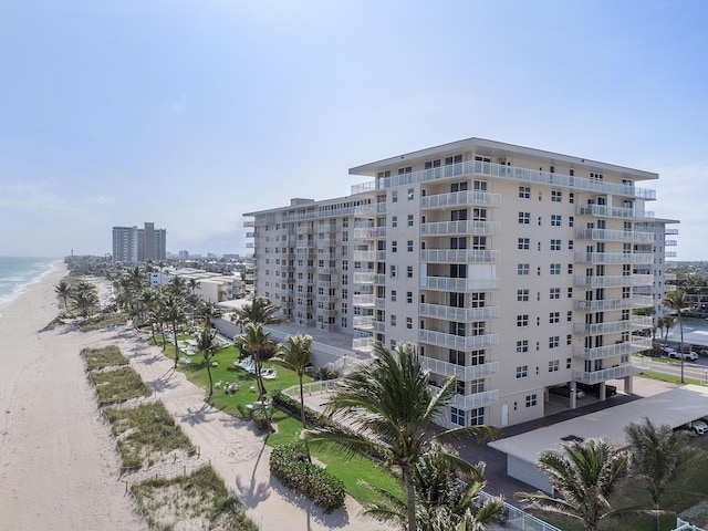 view of building exterior with a beach view and a water view