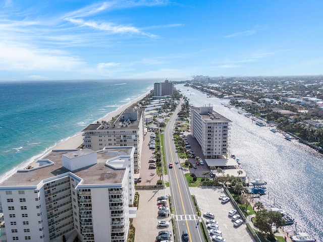 birds eye view of property with a water view and a beach view