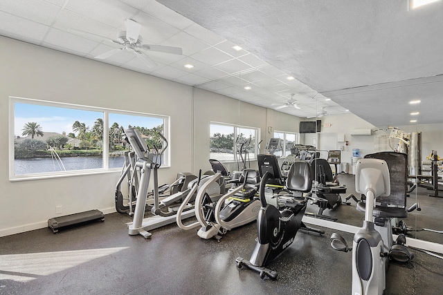 exercise room featuring a water view and ceiling fan