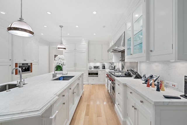 kitchen with sink, white cabinets, and hanging light fixtures