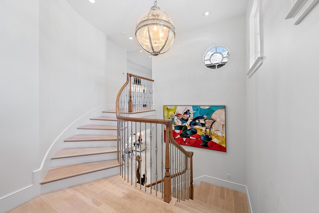 218 Seabreeze Ave, Palm Beach, FL 33480 - staircase featuring healthy amount of natural light, a chandelier, wood finished floors, and recessed lighting
