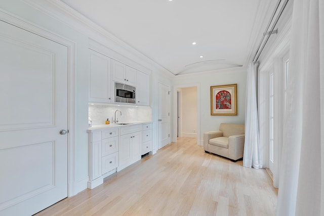 218 Seabreeze Ave, Palm Beach, FL 33480 - living area with light wood-style floors, ornamental molding, recessed lighting, baseboards, and wet bar