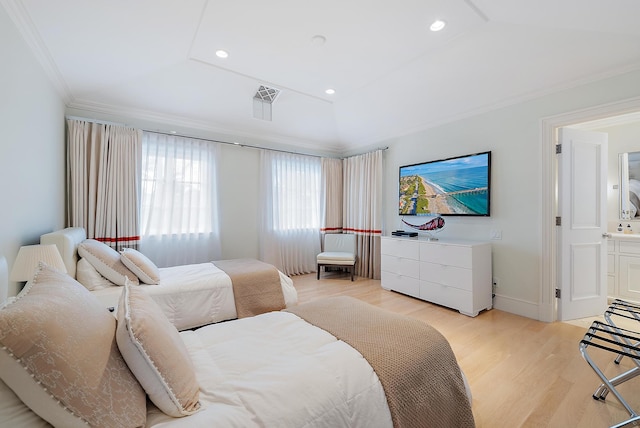 bedroom with connected bathroom, lofted ceiling, ornamental molding, and light hardwood / wood-style floors