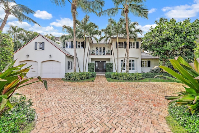 mediterranean / spanish-style house with french doors, a balcony, and a garage