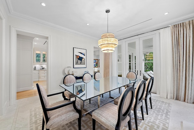 dining area featuring ornamental molding, french doors, and an inviting chandelier