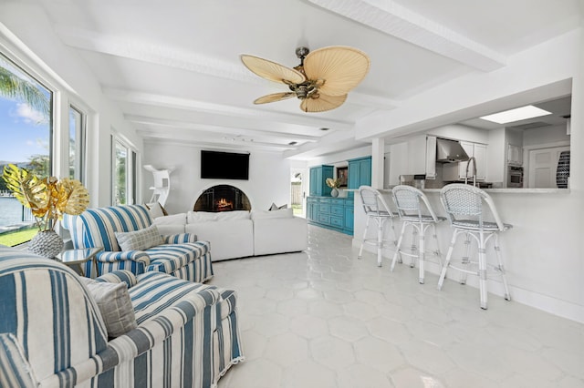 living room featuring ceiling fan and beamed ceiling