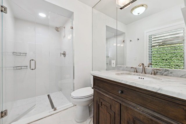 bathroom featuring toilet, a shower with shower door, and vanity