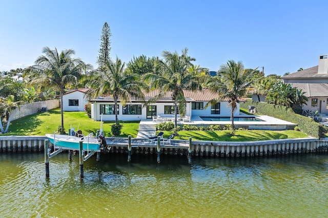 rear view of property featuring a patio, a water view, and a lawn