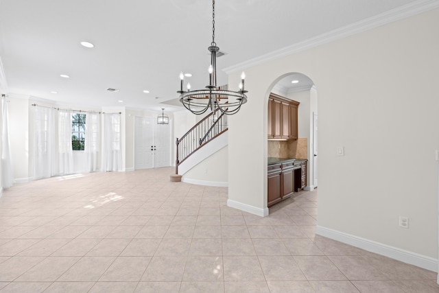 interior space with crown molding, light tile patterned flooring, and an inviting chandelier