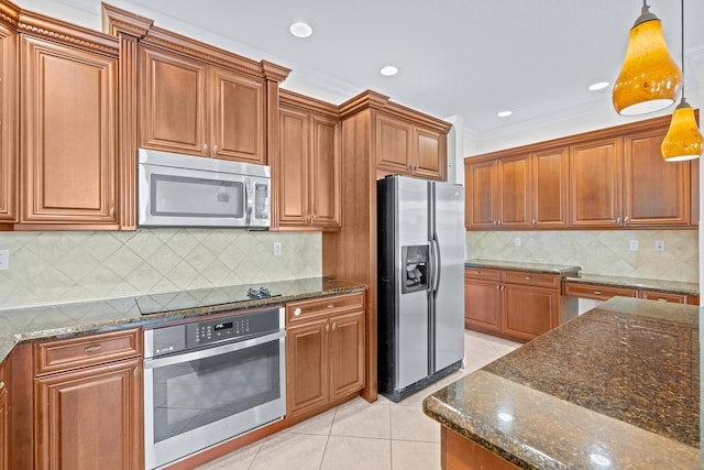 kitchen with appliances with stainless steel finishes, ornamental molding, decorative light fixtures, dark stone countertops, and light tile patterned flooring