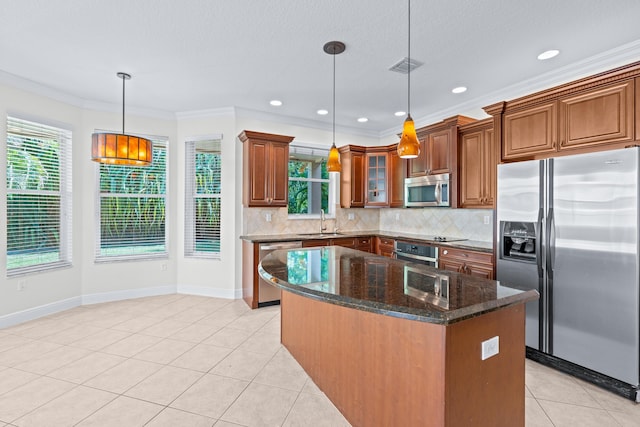 kitchen featuring appliances with stainless steel finishes, ornamental molding, sink, a center island, and hanging light fixtures