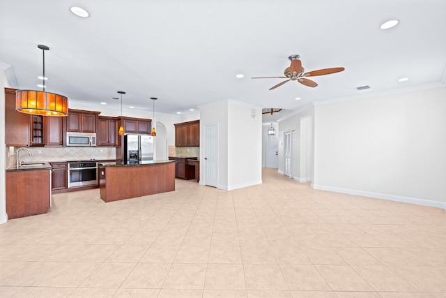 kitchen with sink, a center island, stainless steel appliances, decorative light fixtures, and ornamental molding