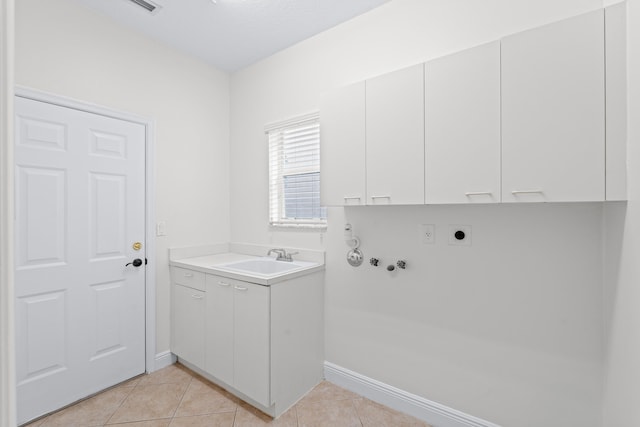 washroom with cabinets, a textured ceiling, electric dryer hookup, sink, and light tile patterned floors