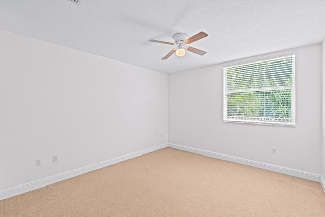 unfurnished room featuring a textured ceiling, carpet floors, and ceiling fan