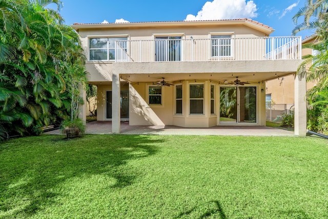 rear view of house featuring a lawn, ceiling fan, a patio area, and a balcony