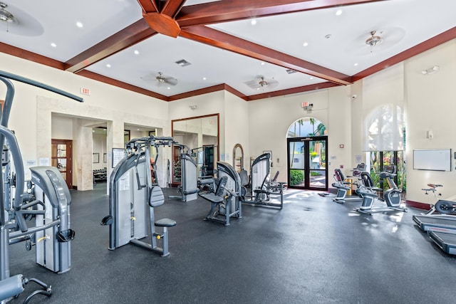 workout area featuring ceiling fan, crown molding, and a towering ceiling