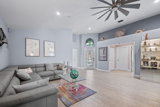 living room with high vaulted ceiling, ceiling fan, and light hardwood / wood-style flooring