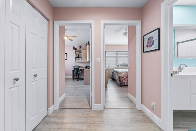 hallway featuring sink and light hardwood / wood-style floors