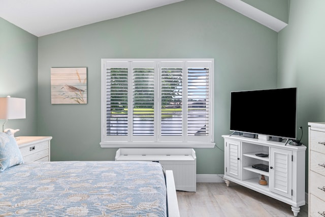 bedroom with vaulted ceiling and light hardwood / wood-style flooring