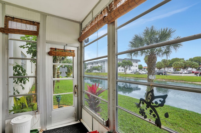 unfurnished sunroom featuring a water view