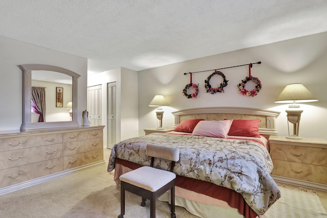 bedroom featuring light colored carpet and a textured ceiling