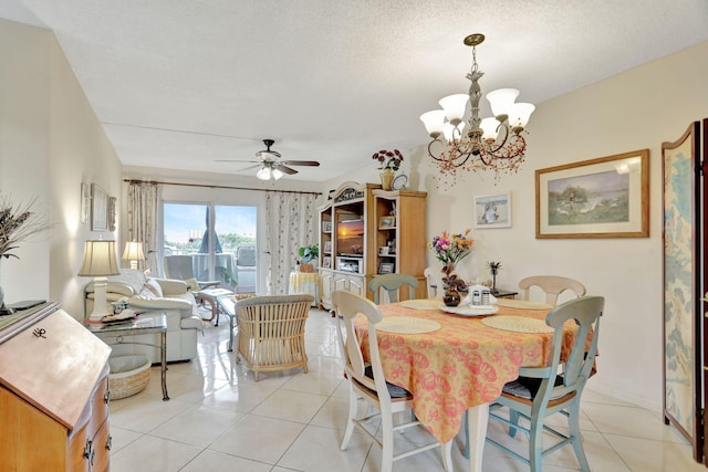 dining space with light tile patterned flooring, ceiling fan with notable chandelier, and a textured ceiling