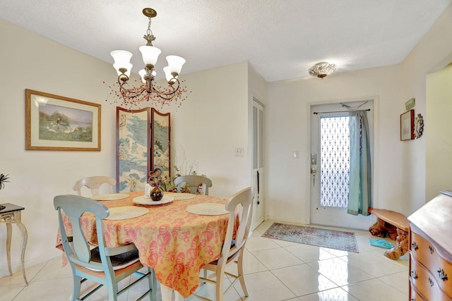 tiled dining area featuring a chandelier and a textured ceiling