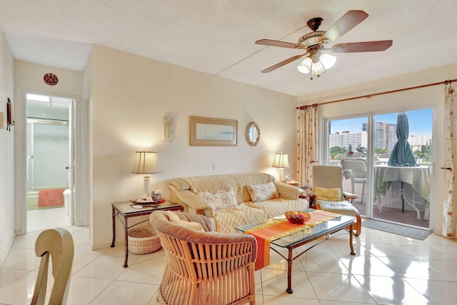 living room featuring ceiling fan, a textured ceiling, and light tile patterned flooring