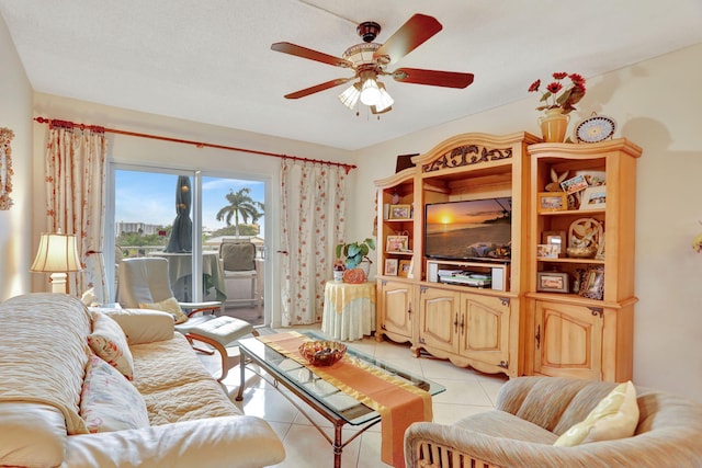 living room featuring ceiling fan, a textured ceiling, and light tile patterned floors