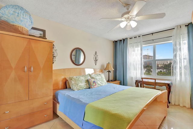 tiled bedroom featuring ceiling fan and a textured ceiling