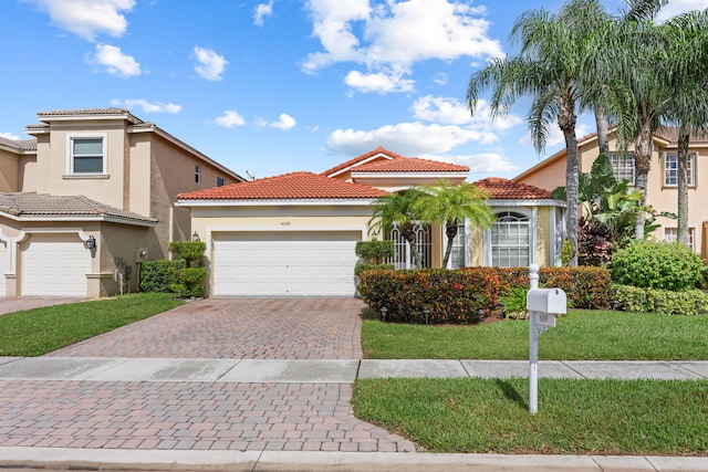 mediterranean / spanish-style house with a front yard and a garage