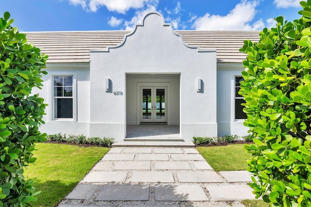 doorway to property with french doors and a lawn