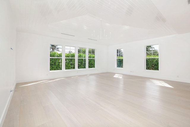 empty room featuring light hardwood / wood-style flooring, vaulted ceiling, and wooden ceiling