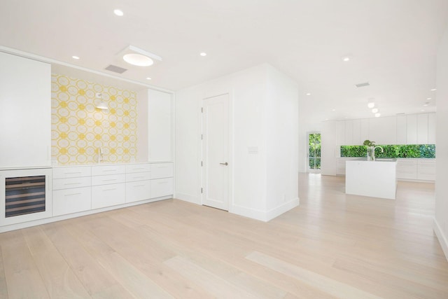 empty room with light hardwood / wood-style floors and sink