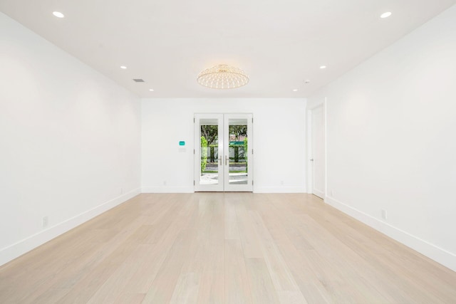 empty room with french doors and light hardwood / wood-style floors