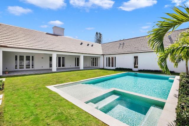 view of pool featuring a patio area, a lawn, and an in ground hot tub