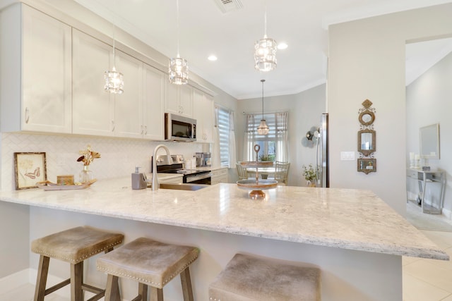 kitchen with kitchen peninsula, pendant lighting, and appliances with stainless steel finishes