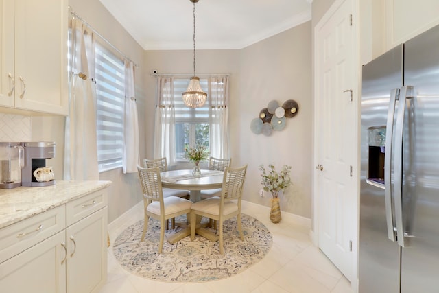 tiled dining room featuring a chandelier and crown molding