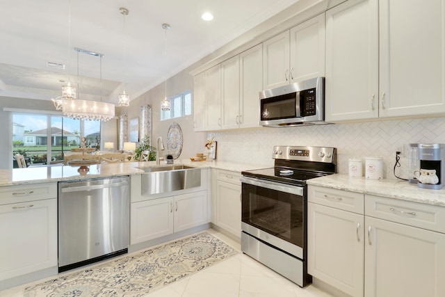 kitchen featuring stainless steel appliances, plenty of natural light, sink, and decorative light fixtures