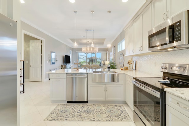 kitchen featuring kitchen peninsula, appliances with stainless steel finishes, hanging light fixtures, and backsplash