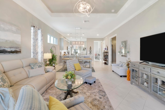 living room featuring a notable chandelier, crown molding, and a tray ceiling