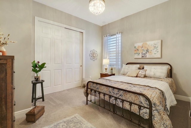 carpeted bedroom featuring a closet and an inviting chandelier