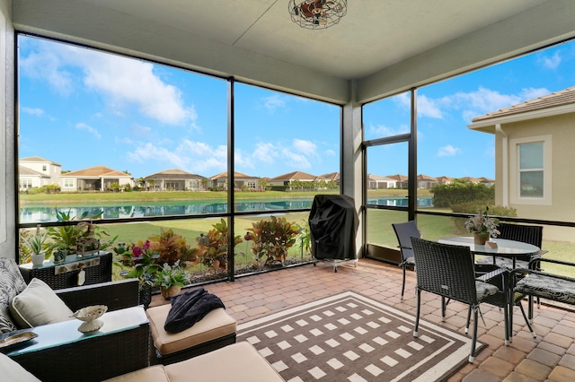 sunroom featuring a water view