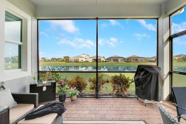 sunroom / solarium featuring a water view