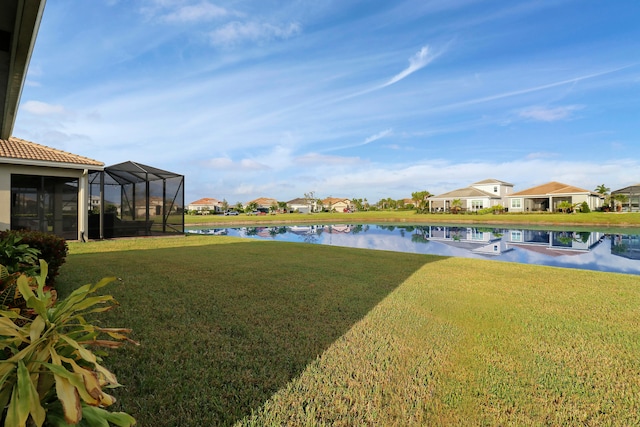 view of yard with a water view and glass enclosure